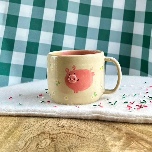 kubek Świnki wśród stokrotek