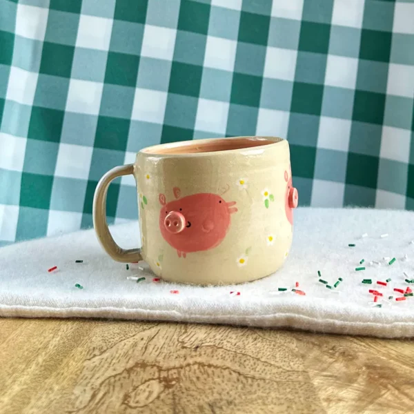 kubek Świnki wśród stokrotek